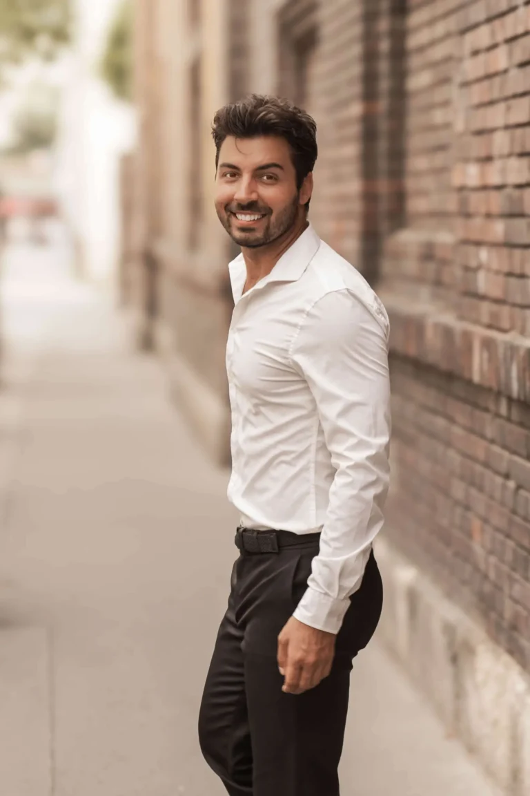 Elegant black-and-white standing pose of a male model with a subtle smile