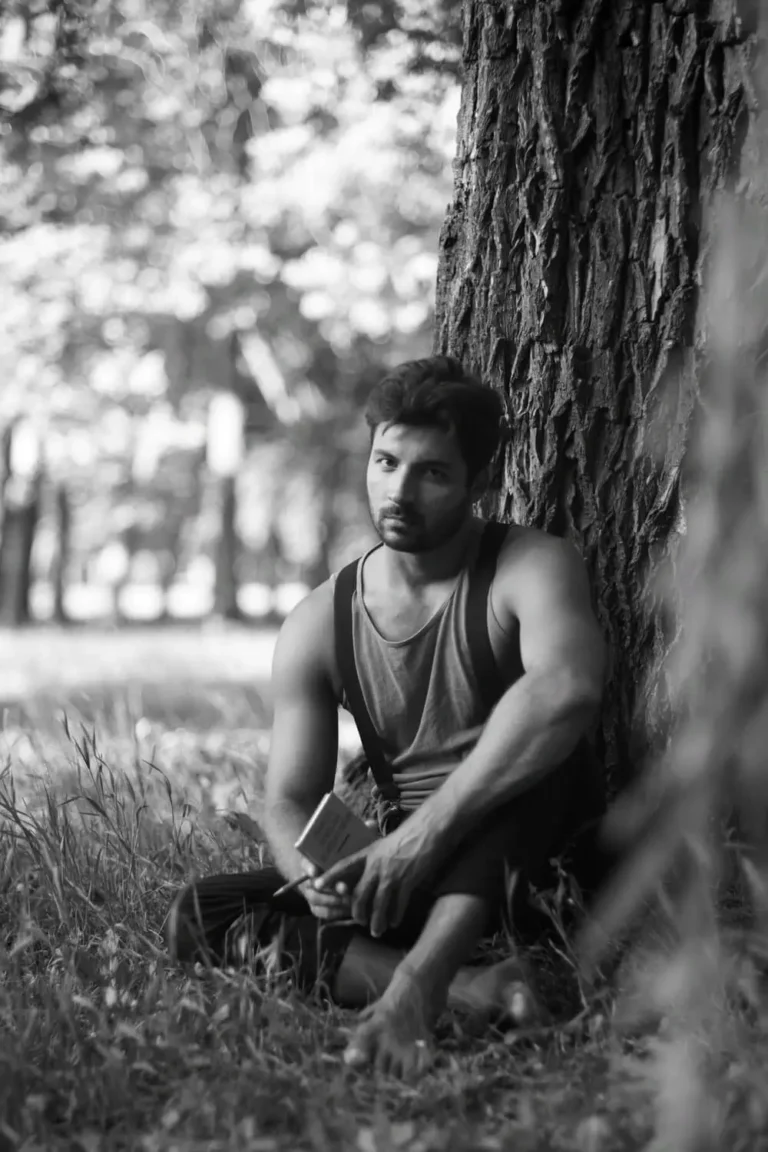 Male model is sitting under a tree